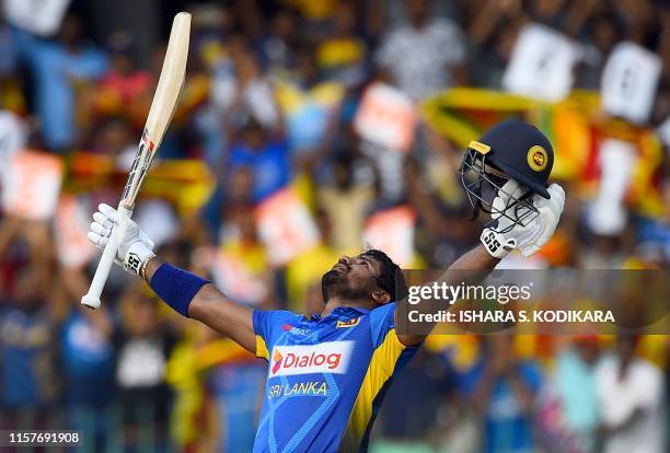 Sri Lankan cricketer Kusal Perera celebrates after scoring a century during the first One Day International cricket match between Sri Lanka and...