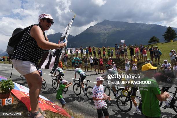 Fans cheer France's Julian Alaphilippe , wearing the overall leader's yellow jersey as he rides up with cyclists of the pack during the nineteenth...