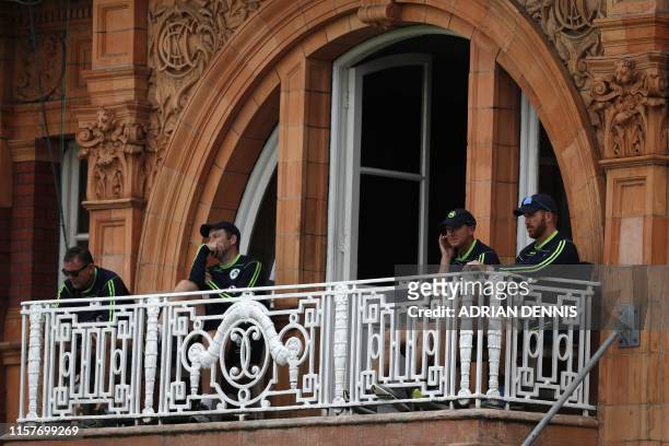Ireland's cricketers look on from the pavilion on the third day of the first cricket Test match between England and Ireland at Lord's cricket ground...