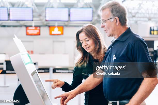 padre e hija usando el totem de check-in en el aeropuerto - tótem fotografías e imágenes de stock