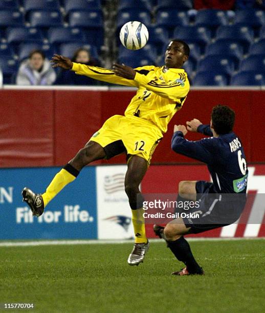 Columbus Crew Edson Buddle, left, heads the ball as New England Revolution Jay Heaps, right, falls to the ground at Gillette Stadium in Foxborough...