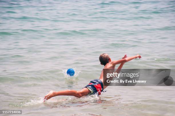 young boy diving for a football - tall skinny blonde stock-fotos und bilder