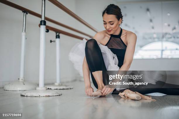junge frau bereitet sich auf ballettausbildung vor - ballettschuh stock-fotos und bilder