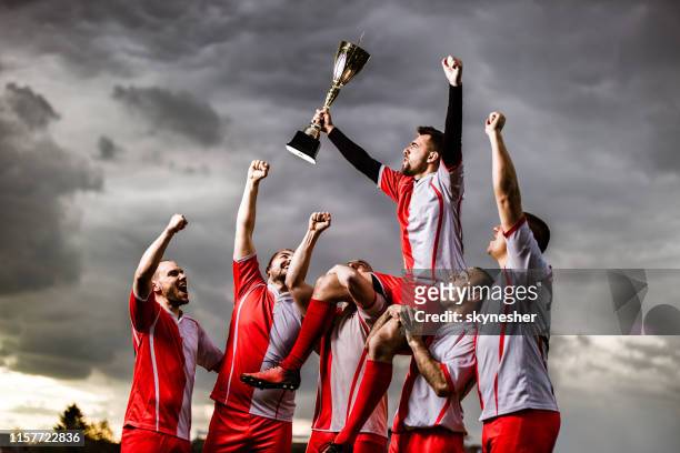 happy sports team celebrating their victory on a playing field. - the championship soccer league stock pictures, royalty-free photos & images