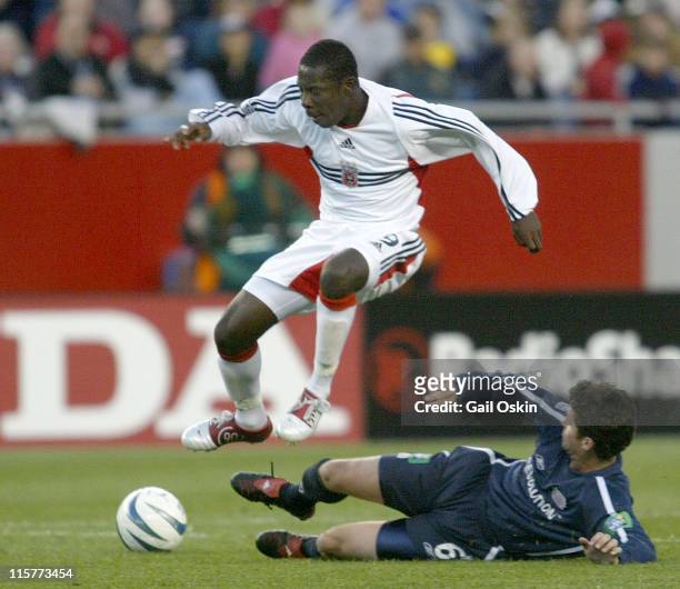 United forward Freddy Adu jumps over New England Revolution defender Jay Heaps during the first half of the game at Gillette Stadium in Foxboro,...
