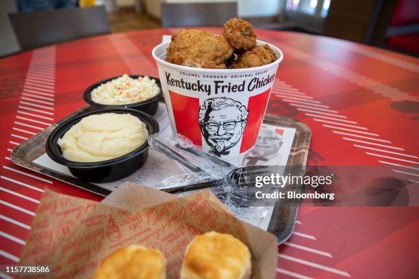 Bucket of fried chicken and side dishes are arranged for a photograph at a Yum! Brands Inc. Kentucky Fried Chicken restaurant in Norwell,...