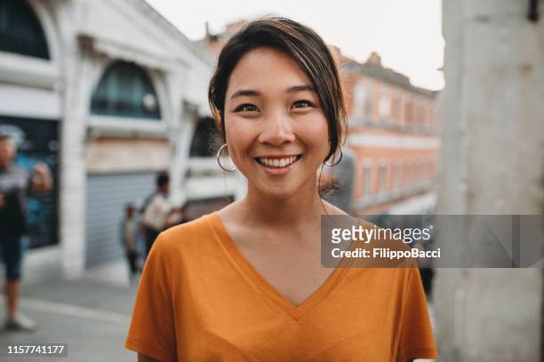 verticale d'une jeune femme asiatique adulte à venise - femme et sourire photos et images de collection
