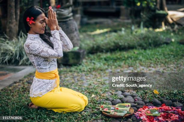 woman practicing yoga with with canang sari - religious offering stock pictures, royalty-free photos & images