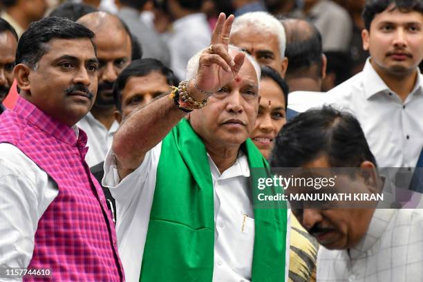 Senior leader of Bharatiya Janata Party , B.S. Yediyurappa , flashes the victory sign to his supporters and party workers prior to his swearing for...