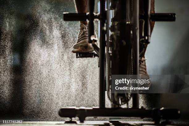 unrecognizable male athlete exercising on stationary bike in a gym. - indoor cycling stock pictures, royalty-free photos & images