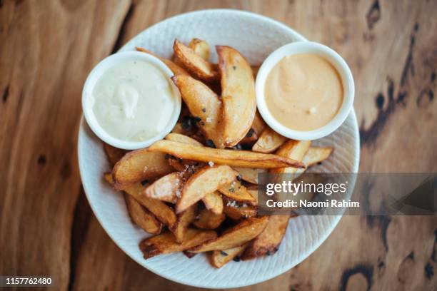 gourmet potato wedges served with black sea salt & aioli in a white bowl, shot directly above - aioli stock-fotos und bilder