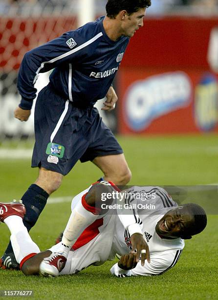 New England Revolution Jay Heaps, above, runs by a downed DC United forward Freddy Adu during the first half of the game at Gillette Stadium in...