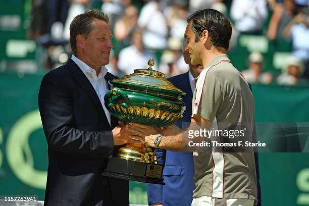 Tournament director Ralf Weber hands over the winners cup to Roger Federer of Switzerland after the final match against David Goffin of Belgium...