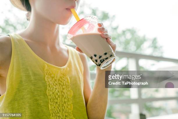 close up of girl drinking bubble tea outdoors - milk tea cup stock pictures, royalty-free photos & images
