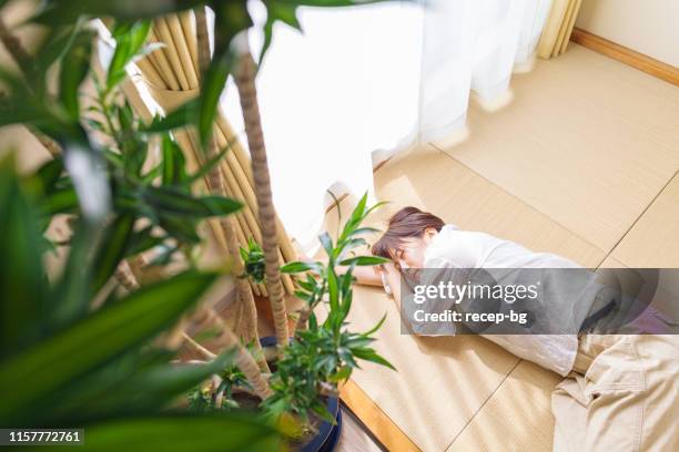 young woman sleeping on tatami mat by window - tatami mat stock pictures, royalty-free photos & images