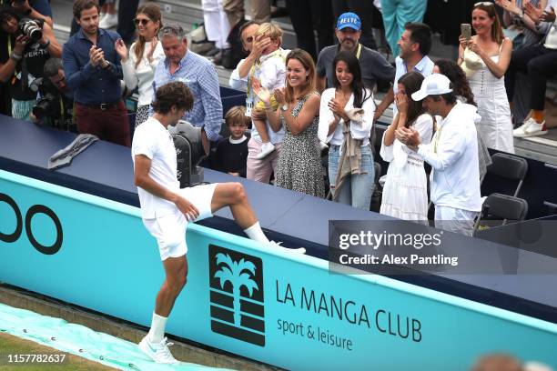 Feliciano Lopez of Spain climbs over the advertising boards to share a kiss with his wife Alba Carrillo after celebrating match point during the mens...