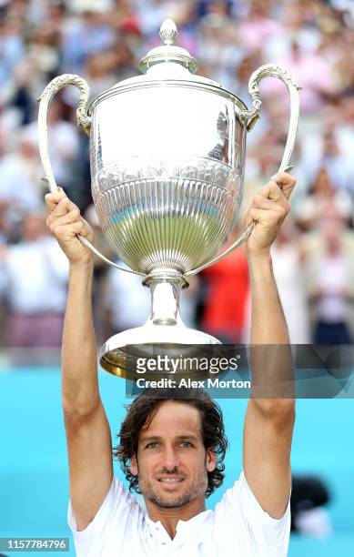 Feliciano Lopez of Spain celebrates victory with the trophy during the mens singles final against Gilles Simon of France during day seven of the...
