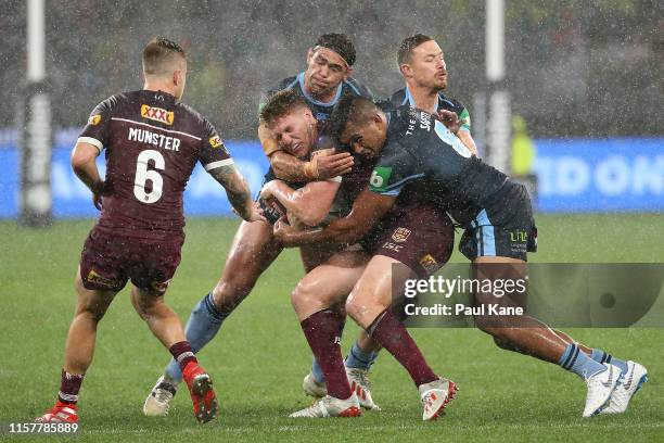 Dylan Napa of Queensland gets tackled by Dale Finucane , Daniel Saifiti and Damien Cook of New South Wales during game two of the 2019 State of...