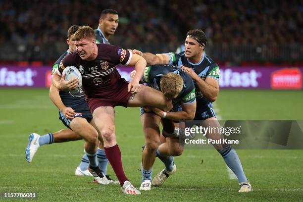 Dylan Napa of Queensland gets tackled by Jake Trbojevic of New South Wales during game two of the 2019 State of Origin series between the New South...