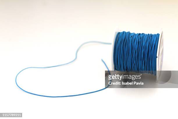 close-up of blue thread spool on fabric - thread sewing item stock-fotos und bilder