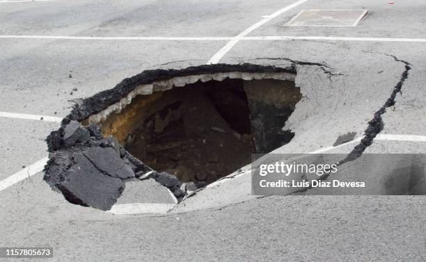 parking destroyed by the effects of rain - pothole stock pictures, royalty-free photos & images