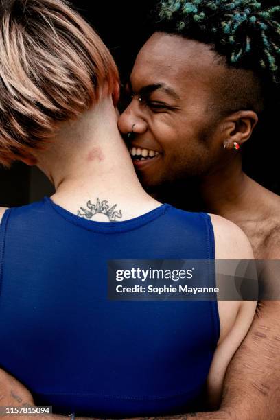 A young LGBT couple laughing and hugging