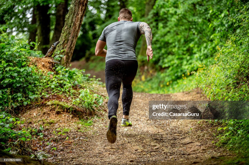 Beslutsam Mid Adult jogging i skogen