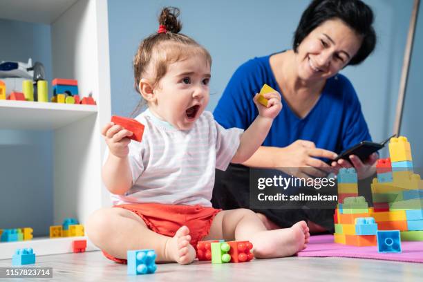 handy süchtig mutter und baby mädchen - sittar stock-fotos und bilder