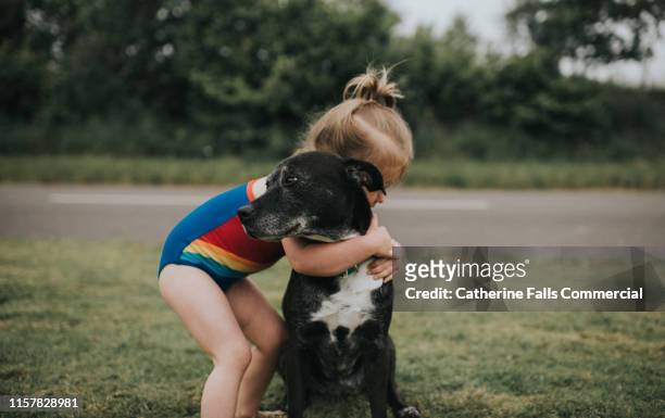 girl hugs dog - kid and dog stock-fotos und bilder