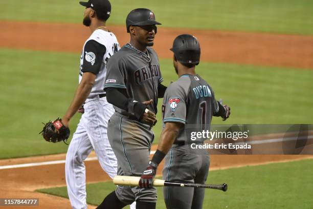 Adam Jones of the Arizona Diamondbacks is congratulated by Jarrod Dyson after scoring in the first inning against the Miami Marlins at Marlins Park...