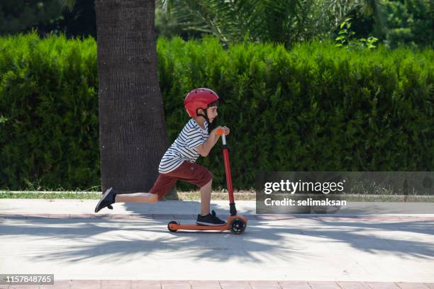 portret van school jongen rijden kick scooter - step stockfoto's en -beelden