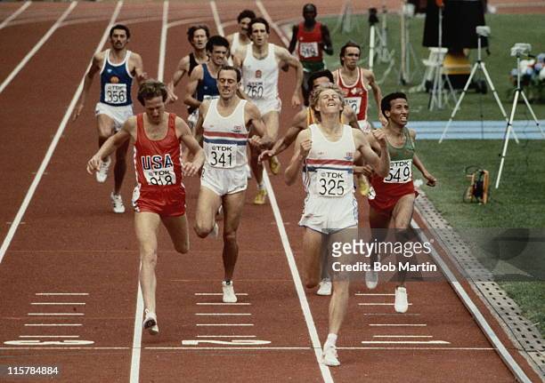 Steve Cram of Great Britain crosses the finishing line to win the Men's 1500 metres final from Steve Scott of the USA and Said Aouita of Morocco...