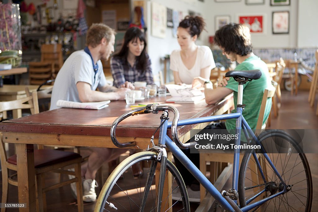 Group of young people in cafe with bike