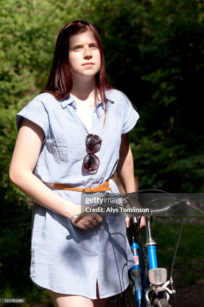 Portrait of young woman holding bike