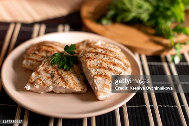 grilled chicken breast in different variations with cherry tomatoes, green french beans, garlic, herbs, cut lemon on a teflon pan. - grilled chicken imagens e fotografias de stock