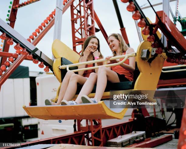 two girls on a ferris wheel - ferris wheel fotografías e imágenes de stock