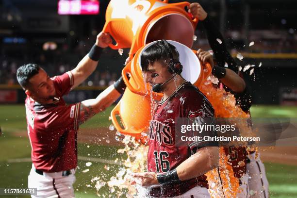 Tim Locastro of the Arizona Diamondbacks is dunked with gatorade from David Peralta and Eduardo Escobar after hitting a walk-off RBI single against...