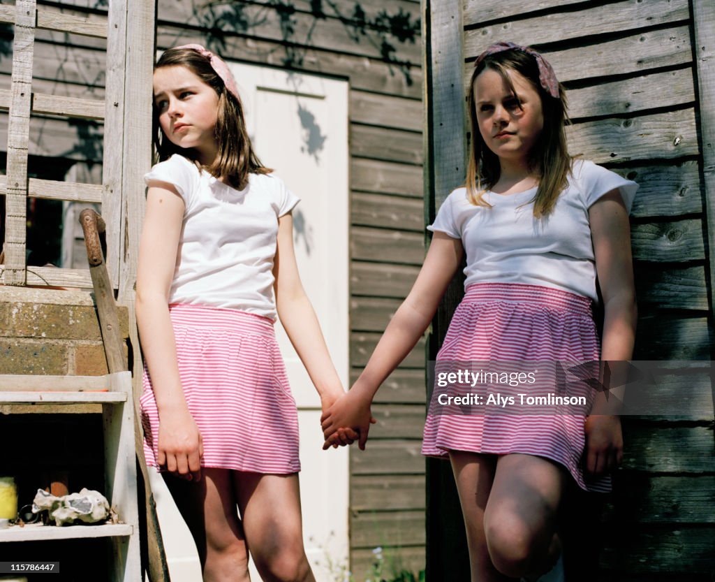 Two Girls in Identical Outfits Holding Hands