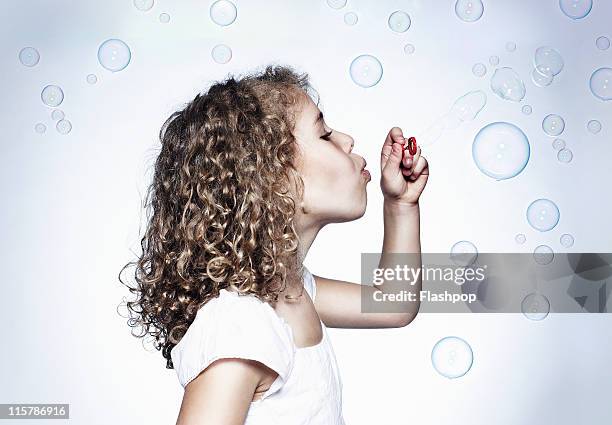 girl blowing bubbles - bubble wand foto e immagini stock