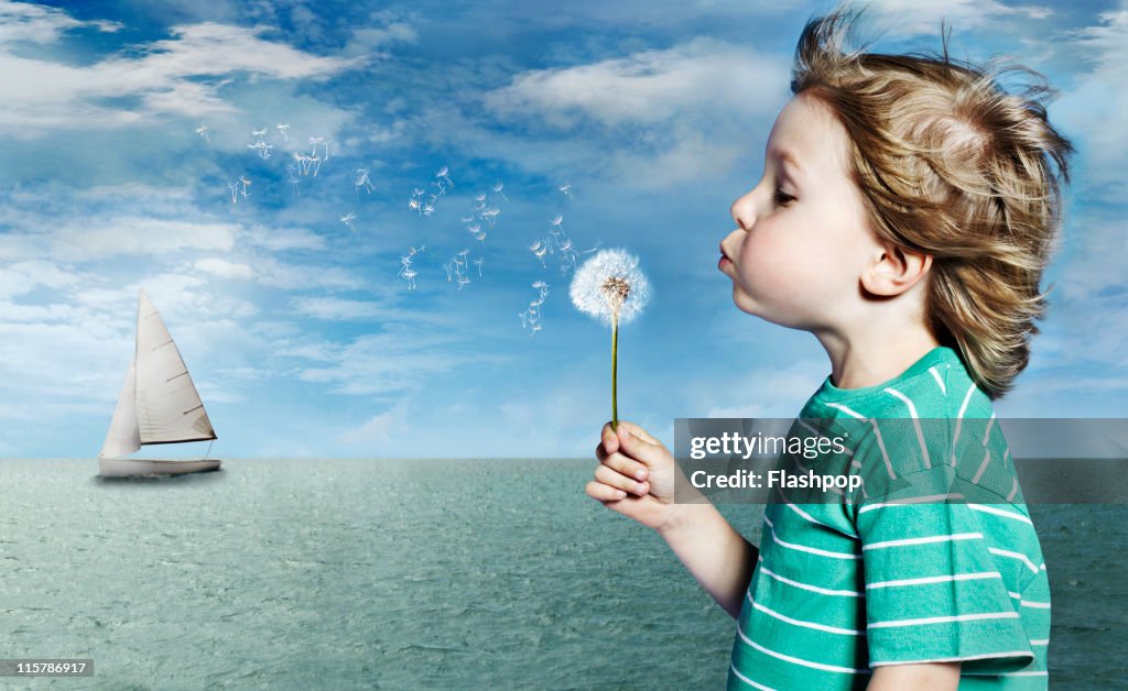 Portrait of boy blowing dandelion clock