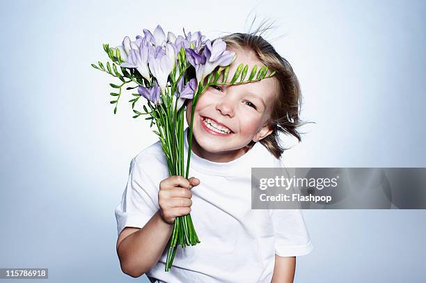 boy smiling holding bunch of flowers - gratitude foto e immagini stock
