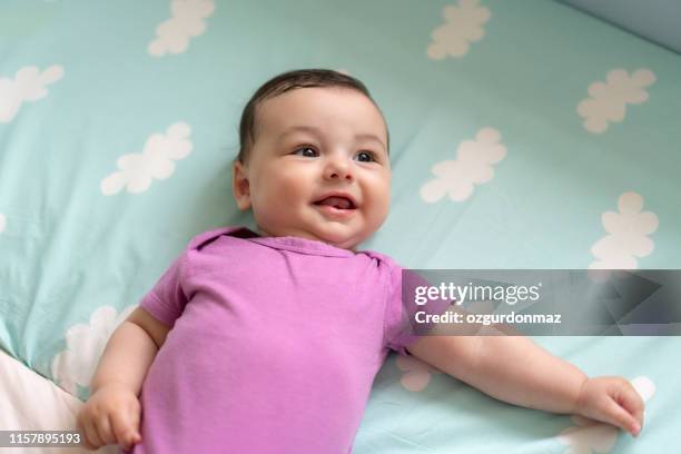 cute baby boy lying in bed - infant bodysuit stock pictures, royalty-free photos & images