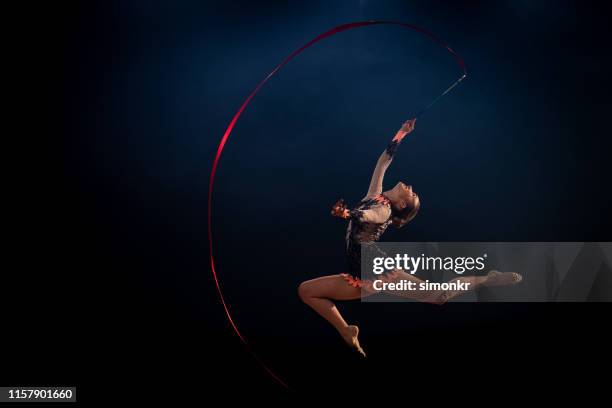 gymnast die ritmische gymnastiek met rood lint doet - ritmische-gymnastiek stockfoto's en -beelden