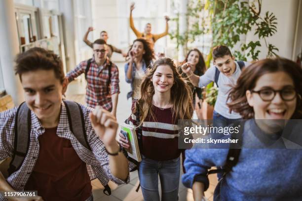 large group of cheerful students running through school hallway. - the end stock pictures, royalty-free photos & images