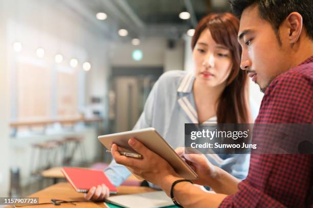 coworkers discussing project in office - korea technology stock pictures, royalty-free photos & images