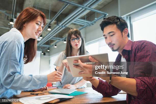 colleagues discussing project in modern office - korean people 個照片及圖片檔