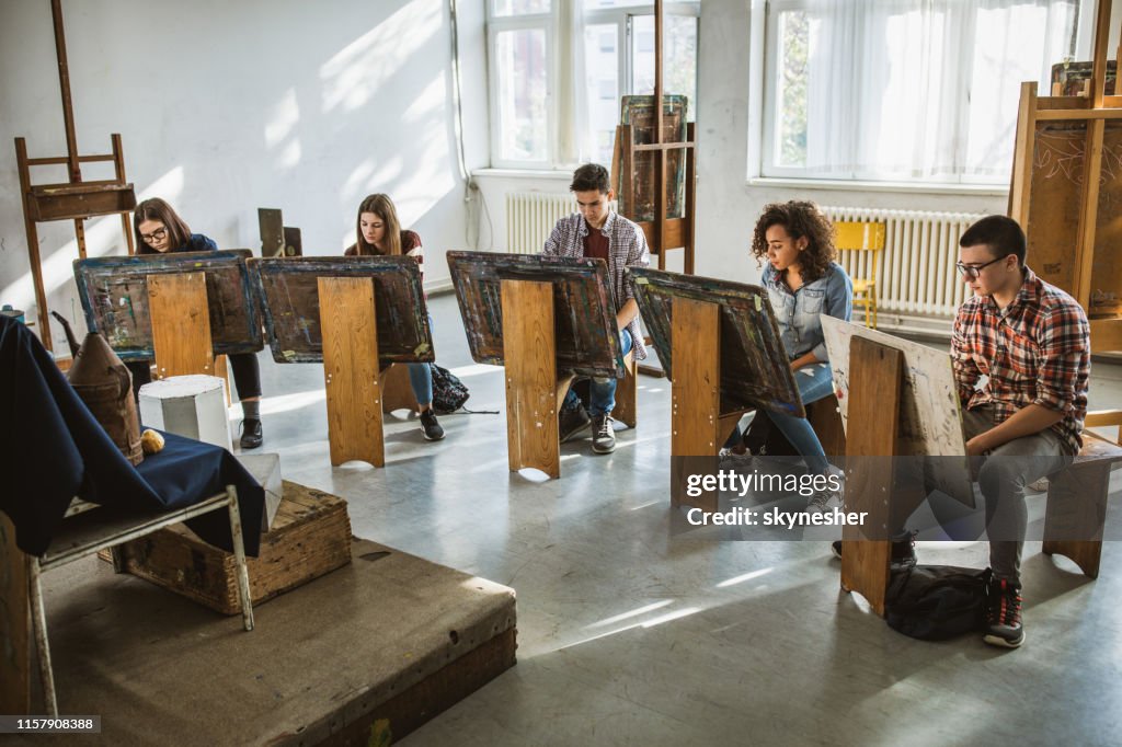 Gruppe von Studenten zeichnen ihre Bilder auf einer Klasse im Kunstatelier.