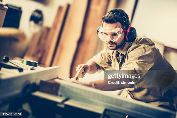 carpenter cutting wood in workshop - khaki stock pictures, royalty-free photos & images