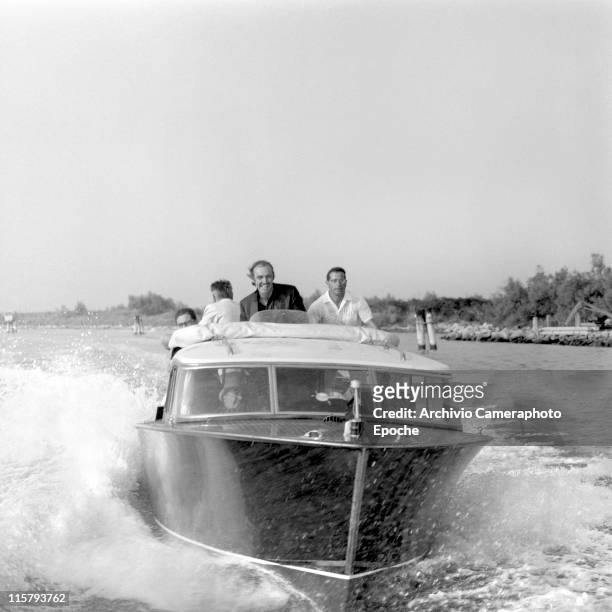 Scottish actor Sean Connery racing on a water taxi with others in the venetian lagoon, Venice 1970s.
