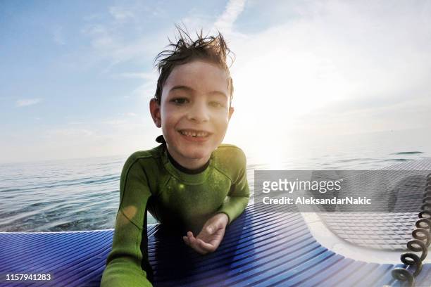little surfer enjoying summer at the sea - wetsuit stock pictures, royalty-free photos & images